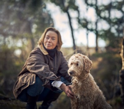 Hund og dame på tur i skogen