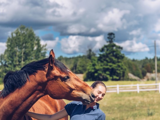 Hest og dame ute på beite
