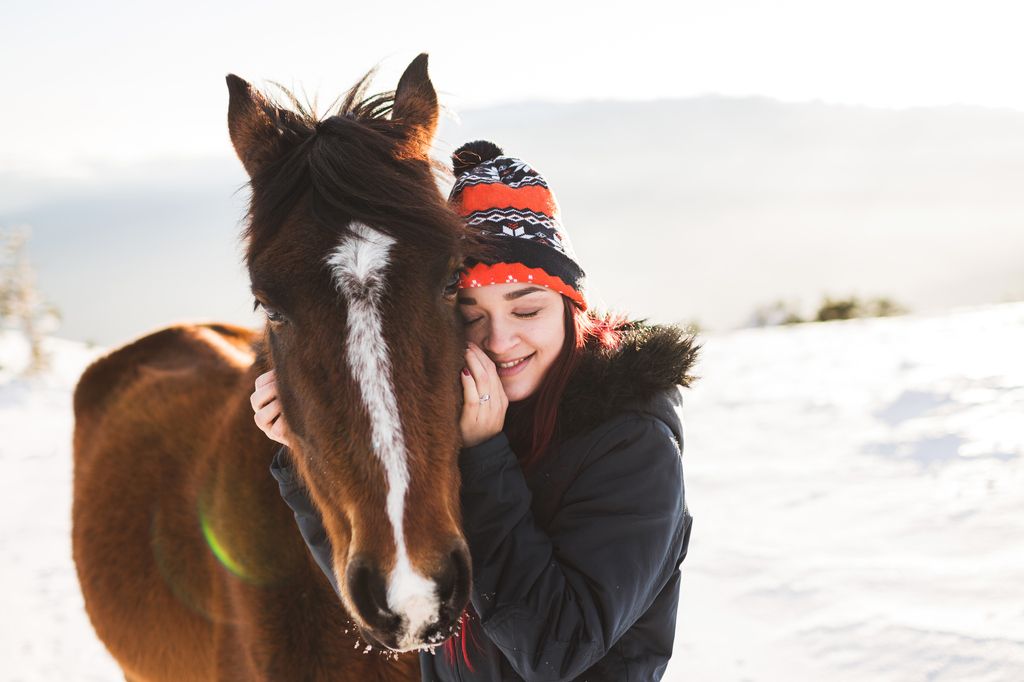 Hest og dame i vinterlandskap