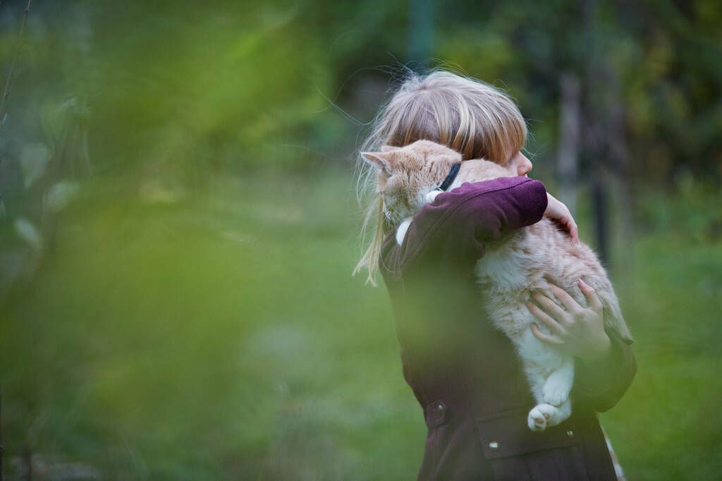 Jente som bærer en katt