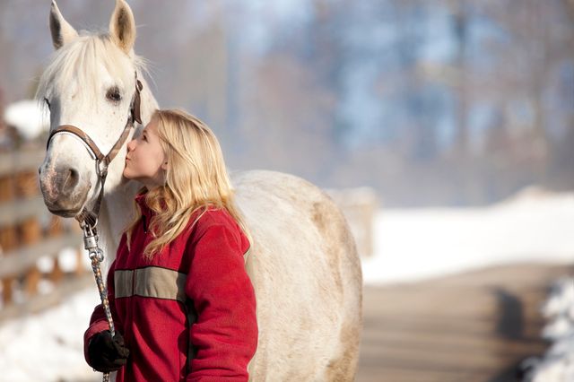 Dame som kysser en hest