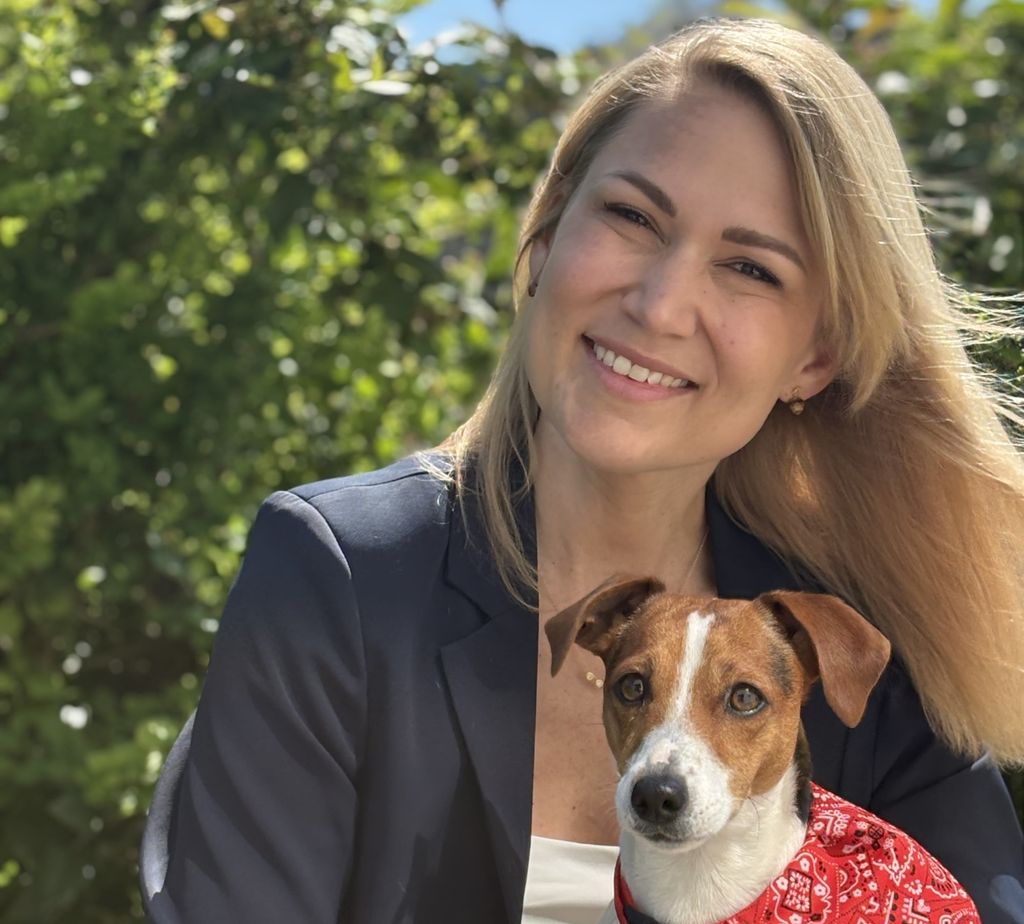 Stine Kronback Arildslund sammen med en brun og hvit hund med rødt skjerf