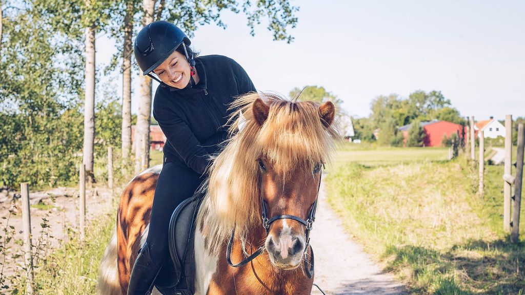 En rytter rir på en ponni ute på en vei