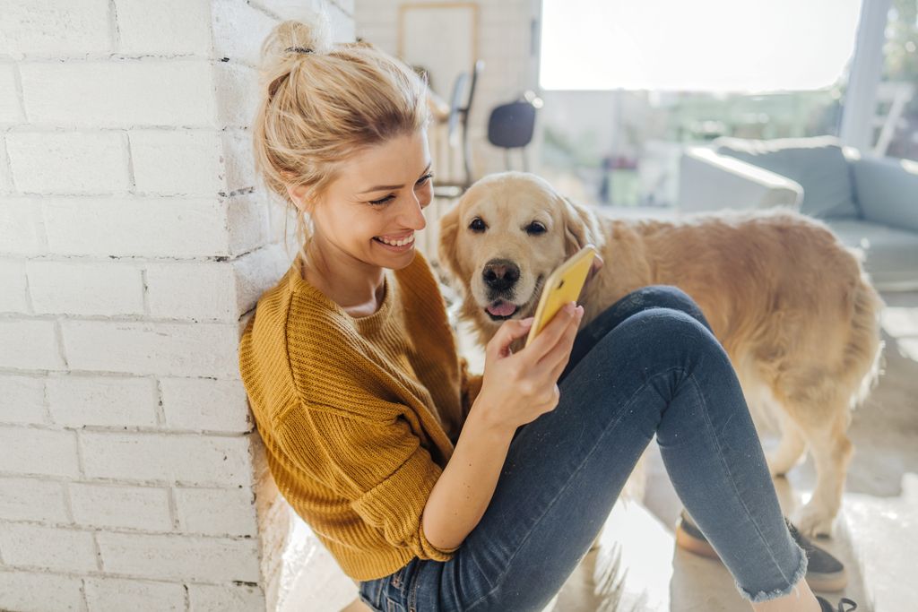 Kvinne som besøker Agrias nettside med en hund ved sin side.