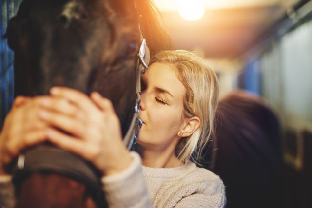 Dame som klemmer en hest