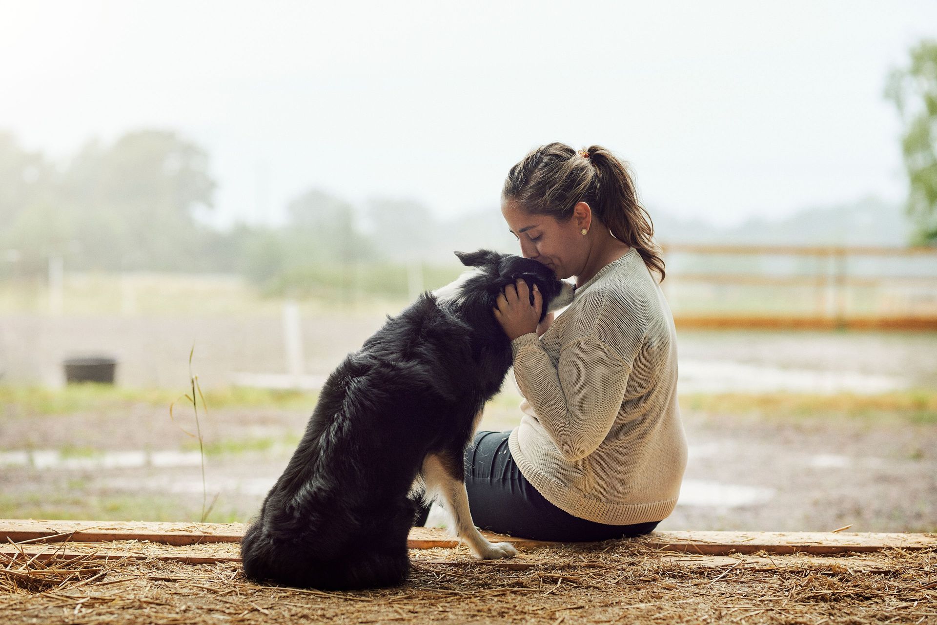 Kvinne gir et kyss til sin border collie på hodet