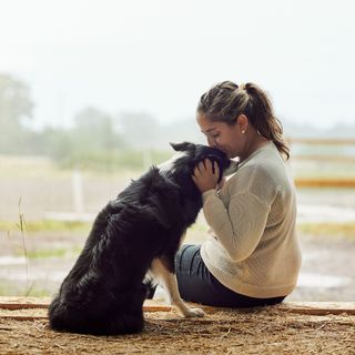 Dame som kysser en hund på hodet