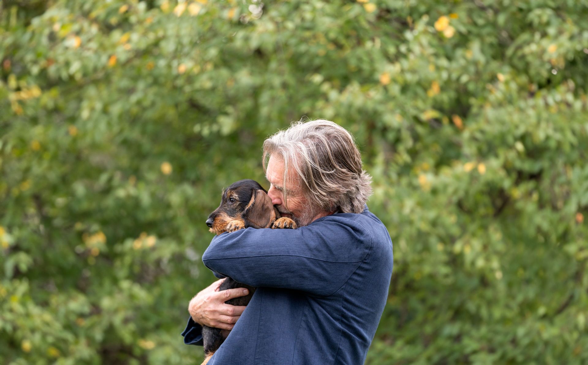 Man koser med en dachshund.