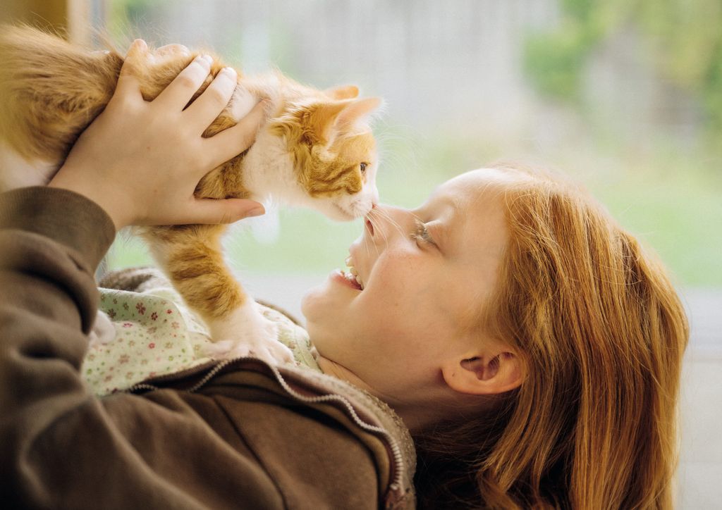 Jente og kattunge koser