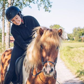 Rytter klapper hesten sin på tur.