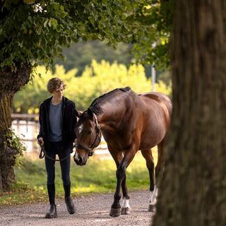 Gutt og hest ute på leietur