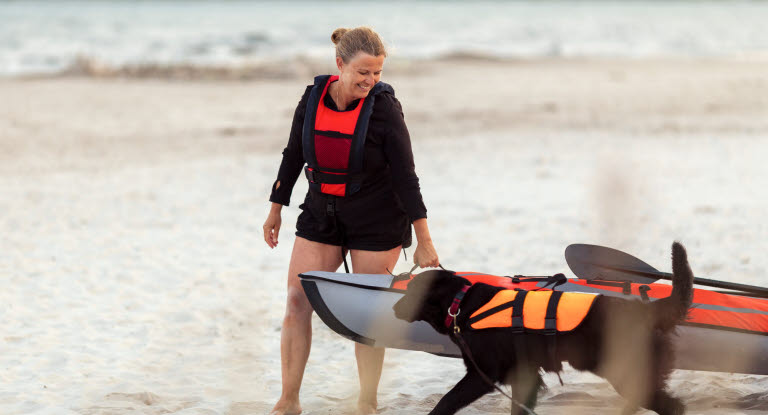 Dame og hund på stranden