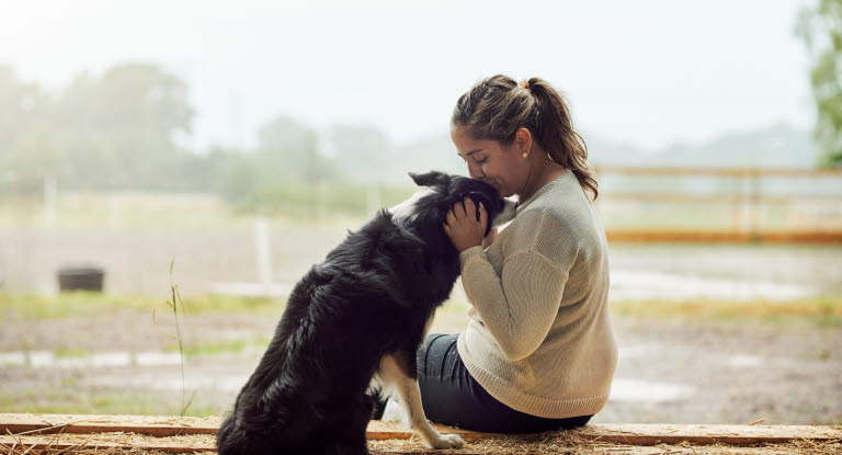 Dame som koser med hund