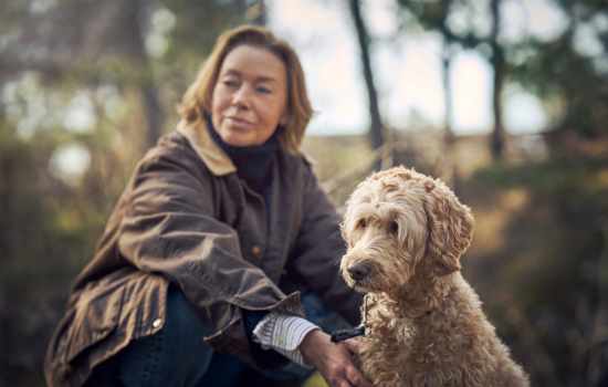 Hund og dame på tur i skogen